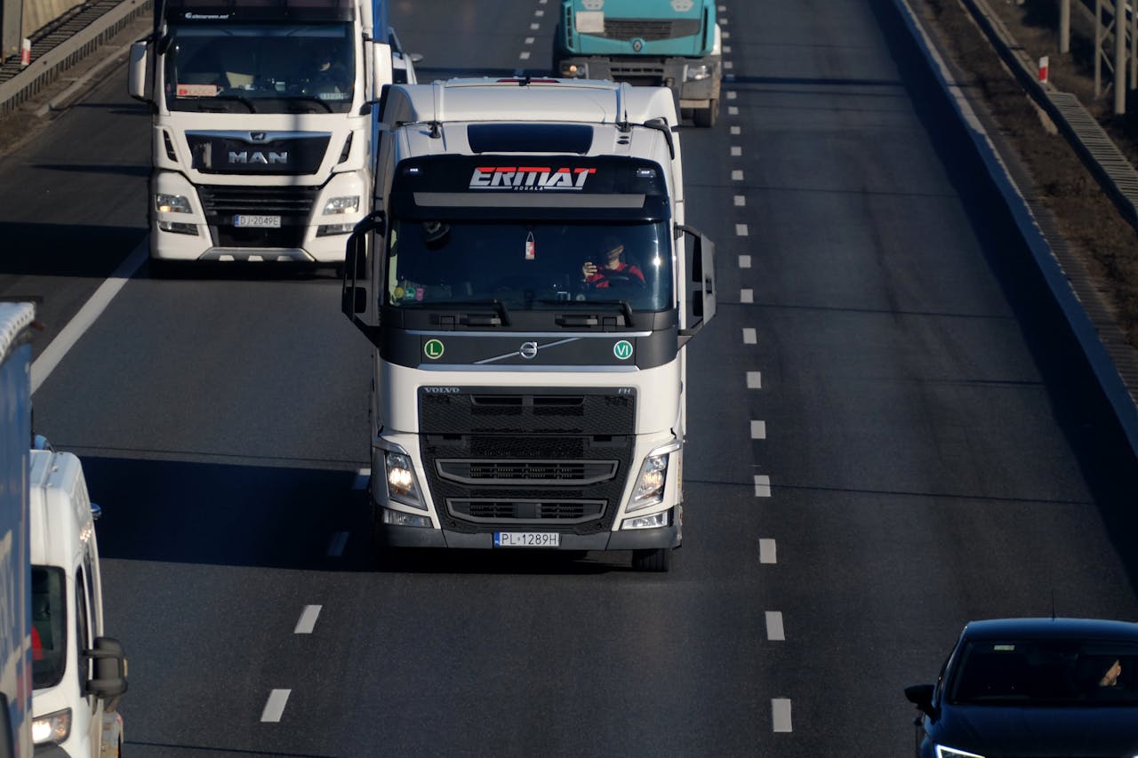 Heavy duty trucks driving on a highway, showcasing transportation and logistics.